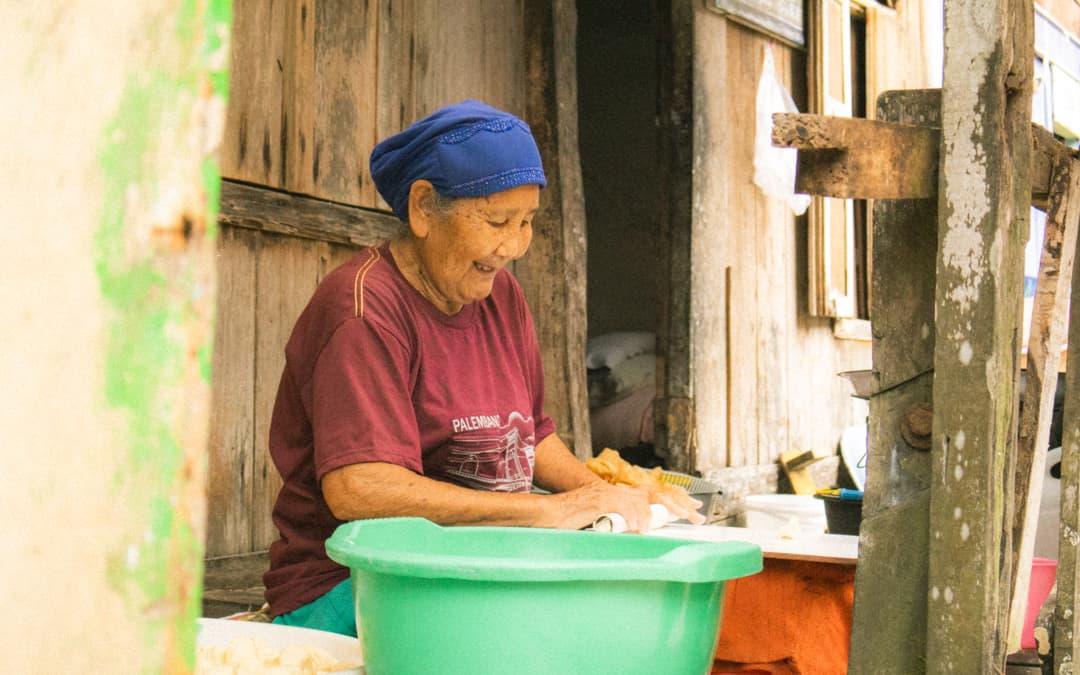 Mujer anciana cocinando en una aldea cerca del río Musi, Sumatra, Indonesia